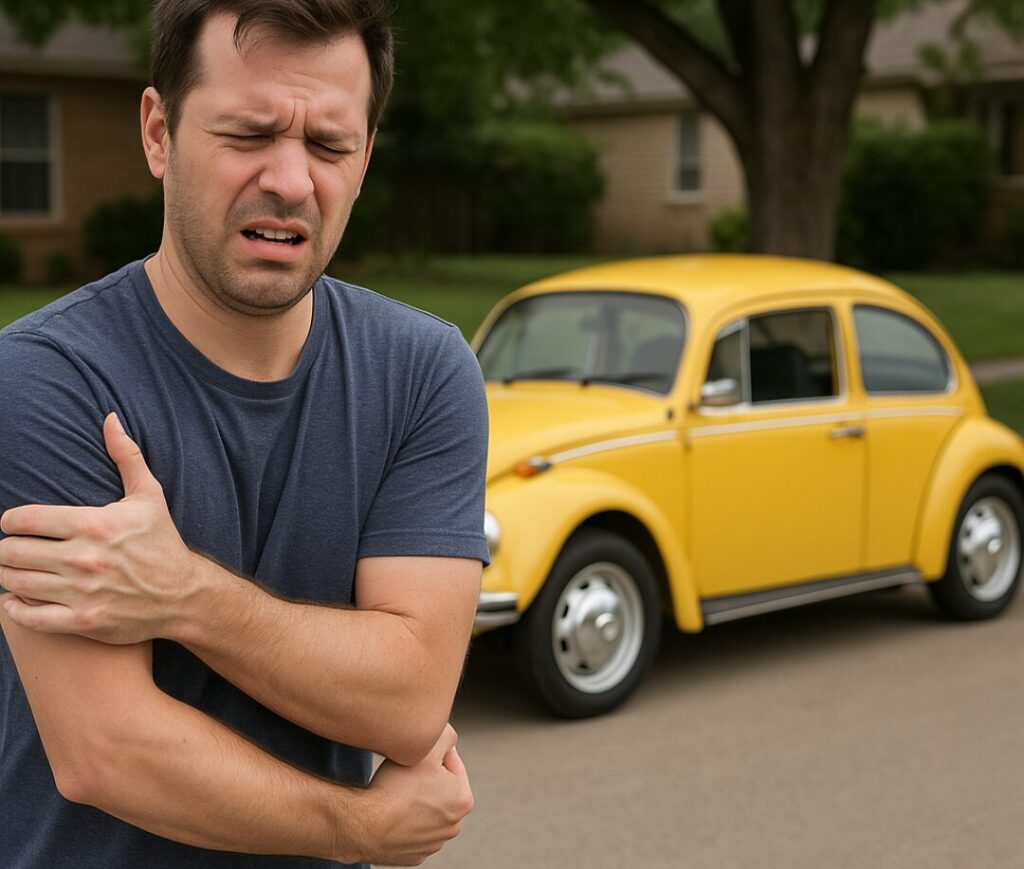A man holding his shoulder in pain after being punched with a parked yellow buggy in the background